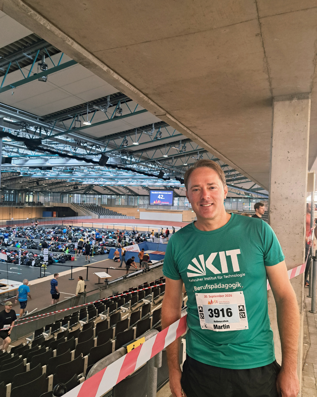 läufer mit Marathon-Trik vor stadionkulisse
