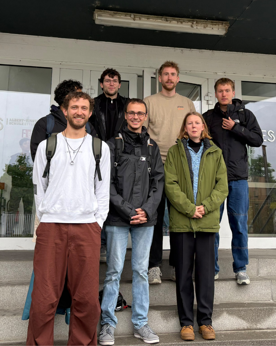 Gruppe von fünf Personen vor einem Gebäude stehend.