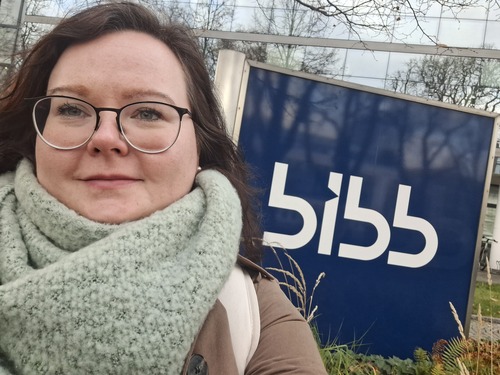 Frau vor dem Schild BIBB