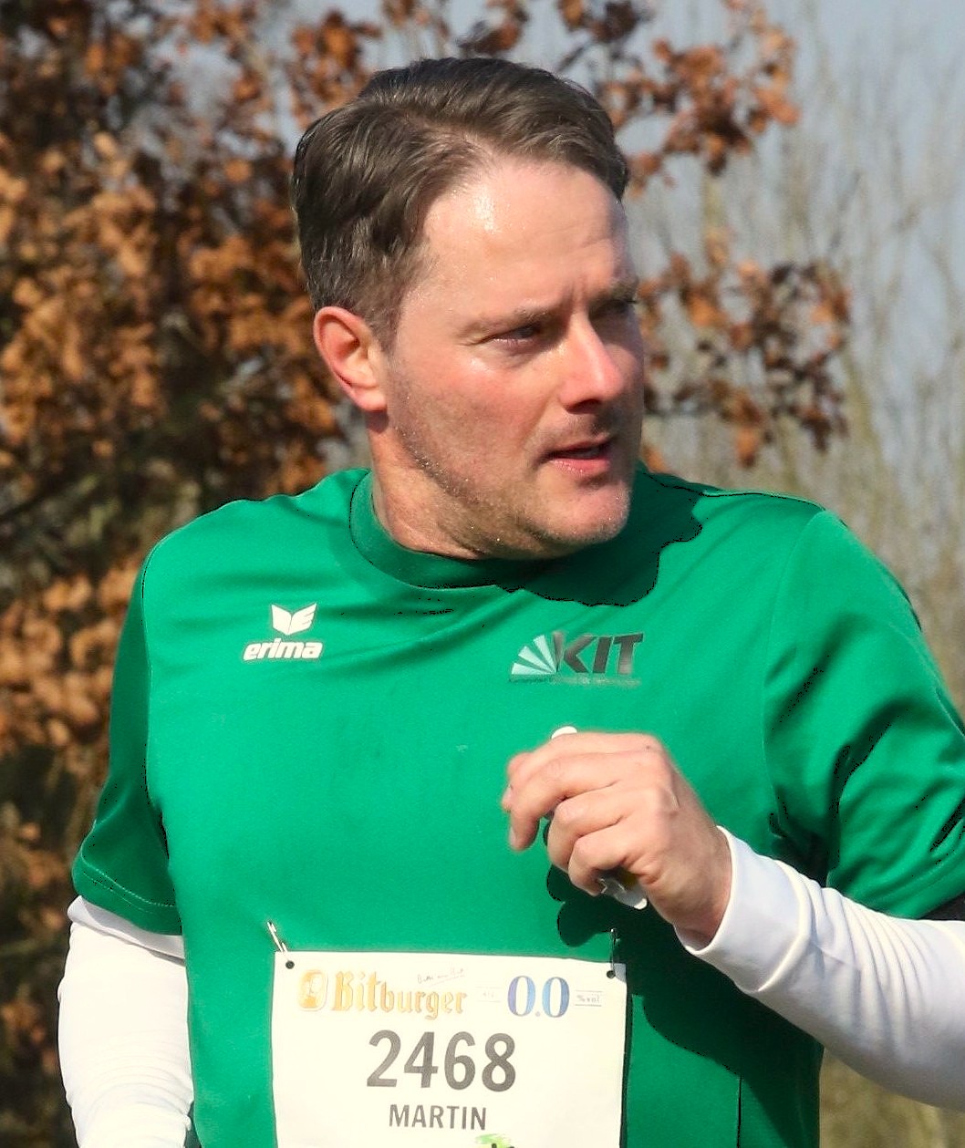 Mann in grüner Laufshirt mit Startnummer 2468, Name Martin, outdoors.