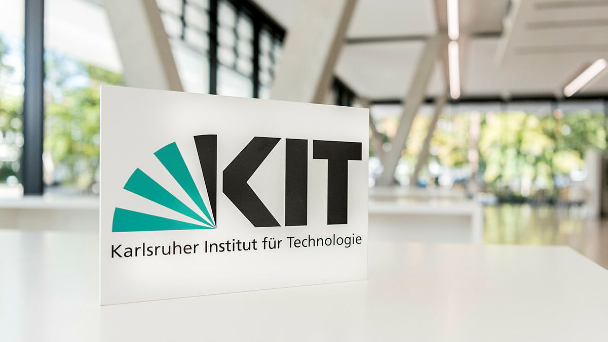 KIT Schild mit Logo des Karlsruher Instituts für Technologie (KIT) in modernem Gebäude.